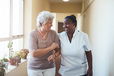 Patient and Nurse walking down hallway while smiling