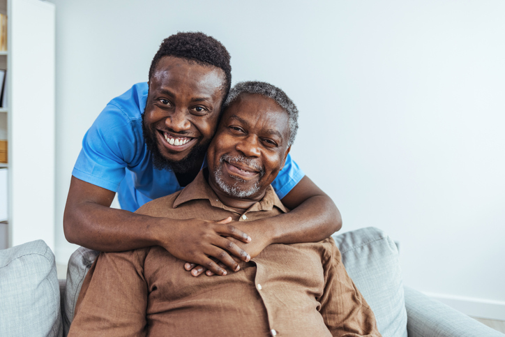 Elderly man with a nurse standing behind him